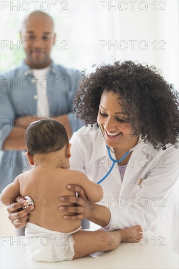 Doctor giving baby a check up in office