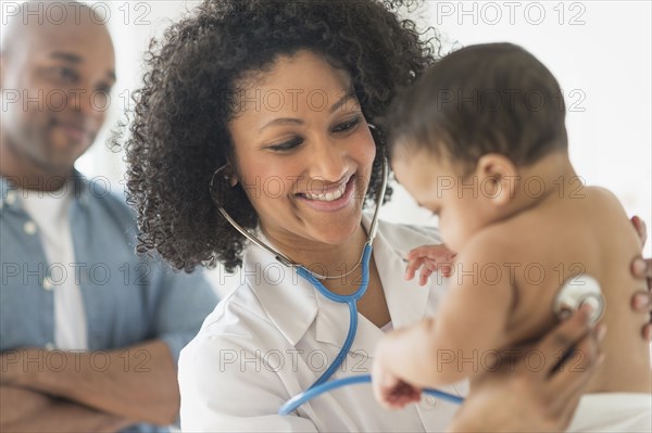 Doctor giving baby a check up in office