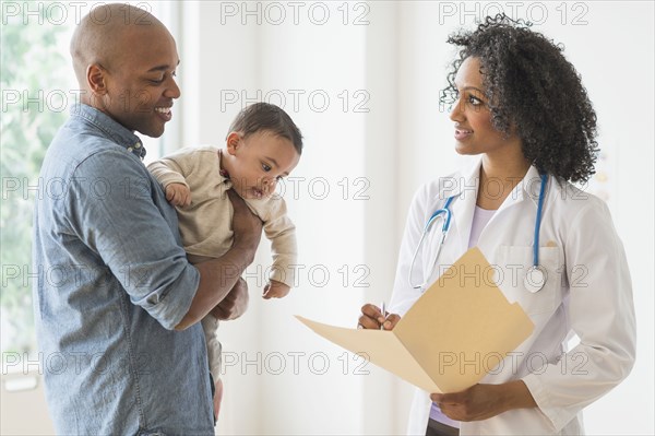 Father with baby talking to doctor