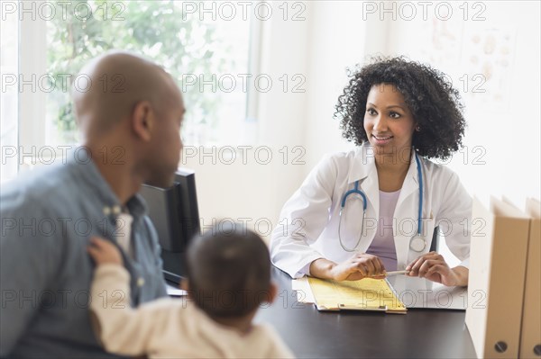 Father with baby talking to doctor