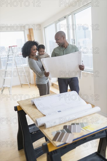 Family examining blueprints in new home