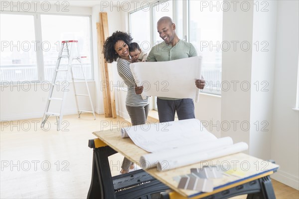 Family examining blueprints in new home