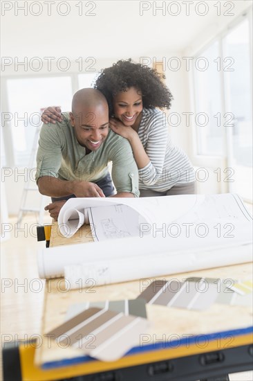 Couple examining blueprints of new home