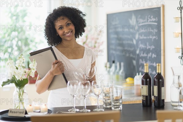 Mixed race hostess smiling in restaurant