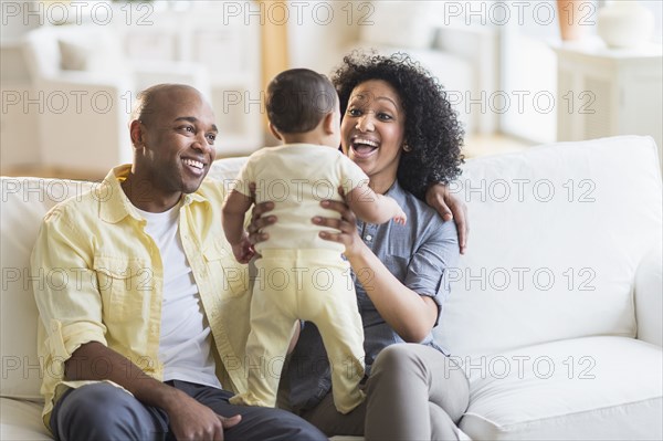 Parents playing with baby in living room