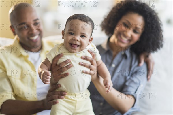 Parents playing with baby in living room