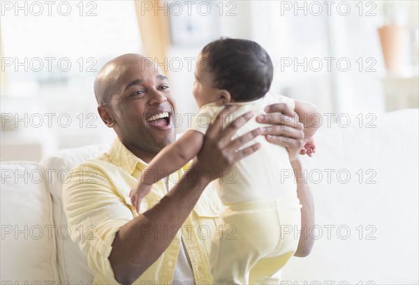 Smiling father playing with baby