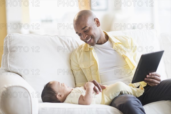 Smiling father playing with baby