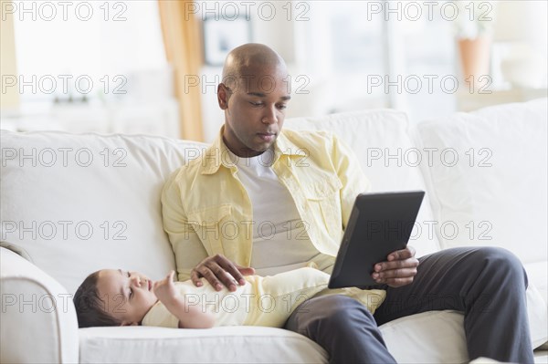 Smiling father relaxing with baby