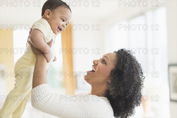 Smiling mother playing with baby