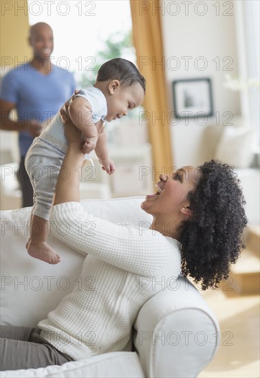 Mixed race mother playing with baby on sofa