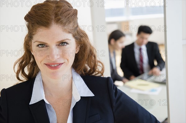 Caucasian businesswoman smiling in office