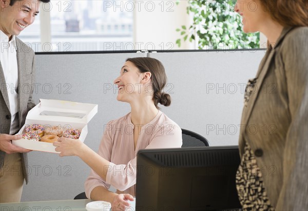Business people having donuts in office