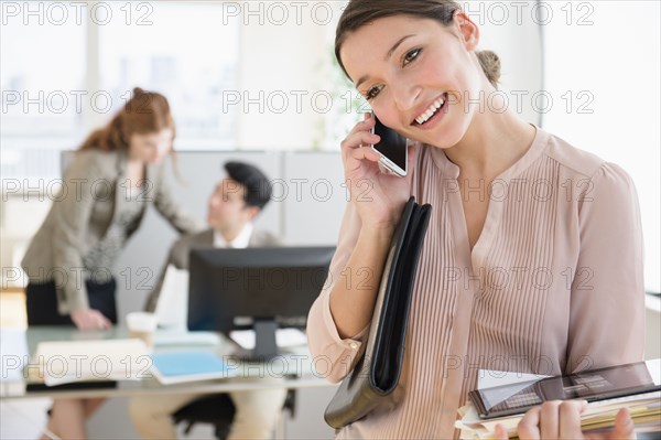 Businesswoman talking on cell phone in office