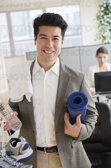 Businessman carrying workout gear in office