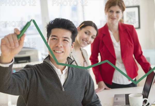Businessman drawing graph on window in office