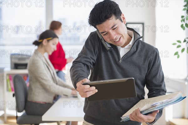 Businessman talking on cell phone in office