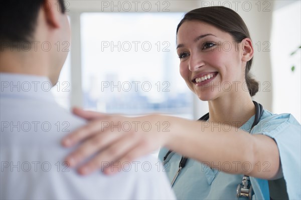 Doctor and nurse hugging in office