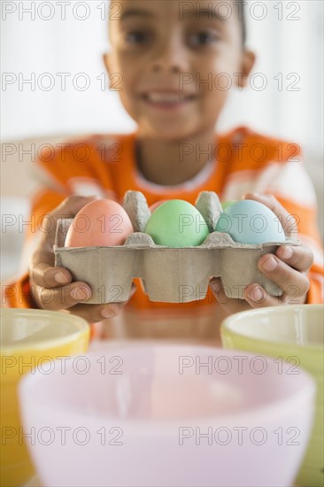 Mixed race boy dyeing Easter eggs
