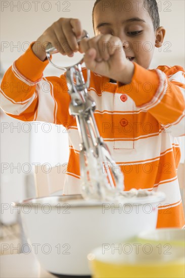 Mixed race boy baking in kitchen