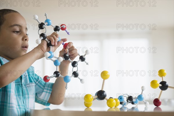 Mixed race boy playing with molecular models