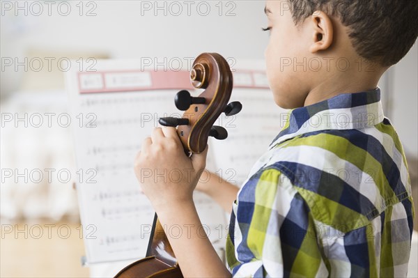 Mixed race boy holding violin