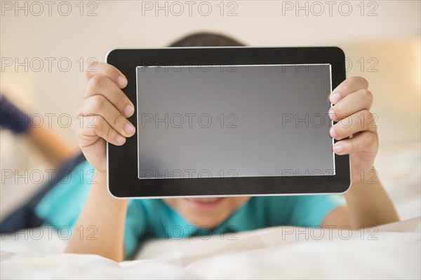 Mixed race boy holding tablet computer