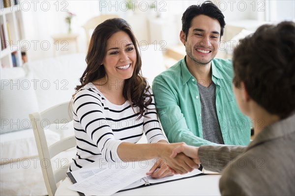 Couple shaking hands with financial adviser