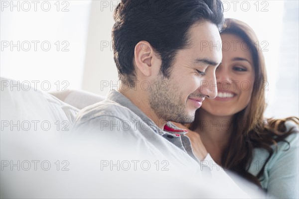 Couple smiling together on sofa