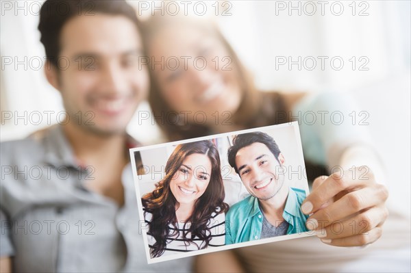 Couple holding photograph of themselves
