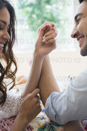 Couple arm wrestling at table