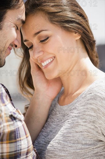 Smiling man caressing face of woman