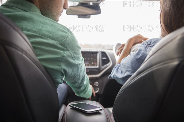 Couple with cell phone in car