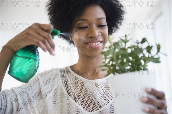 African American woman watering plants