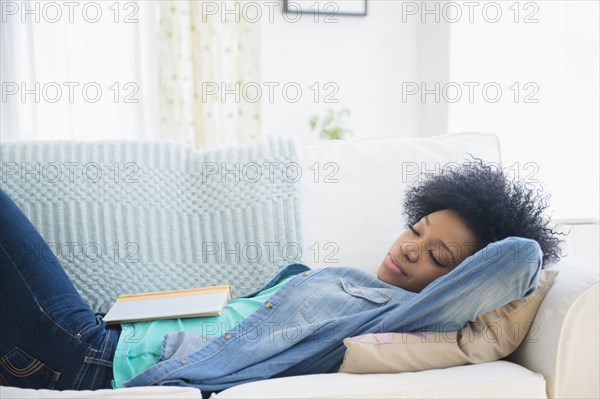 African American woman napping on sofa