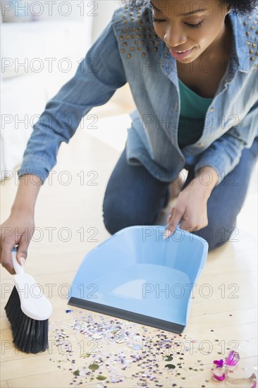African American woman sweeping up confetti