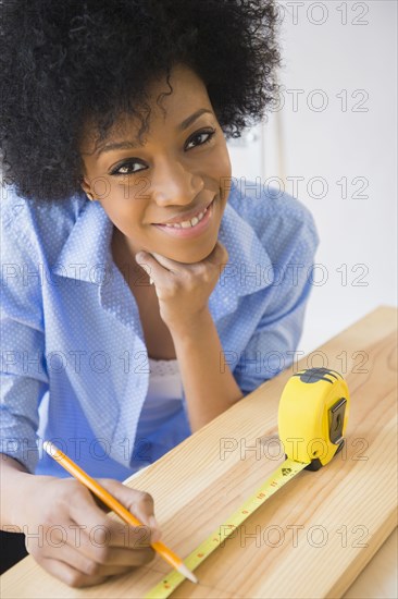 African American woman measuring wood