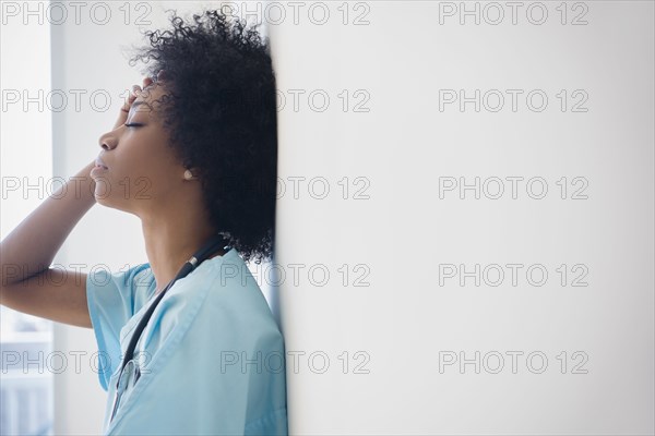 African American nurse leaning against wall
