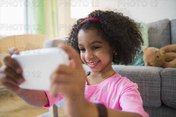 African American girl taking pictures with cell phone