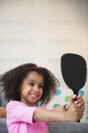 African American girl admiring herself in mirror