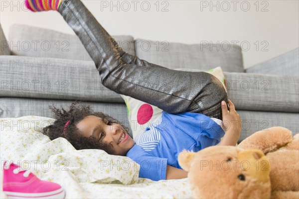 African American girl playing on living room floor