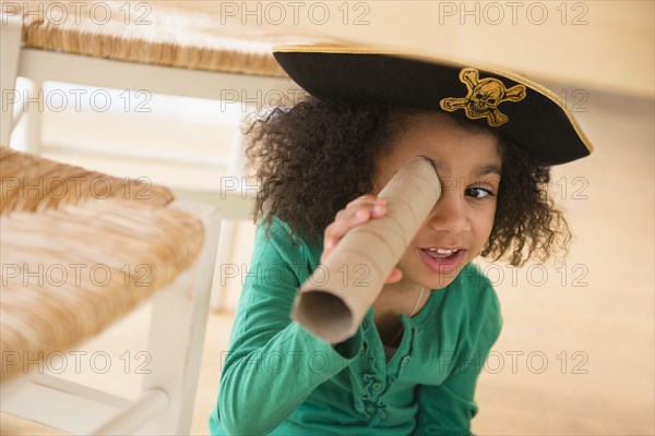 African American girl playing with cardboard tube