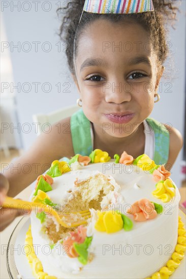 African American girl eating birthday cake