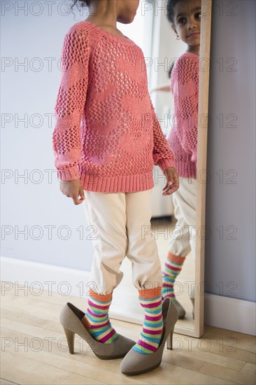 African American girl dressing up in mother's shoes