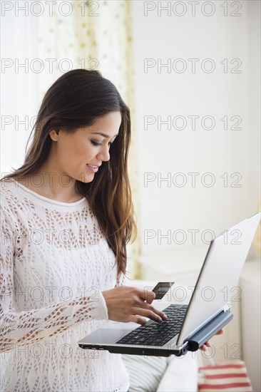 Woman using laptop in bedroom