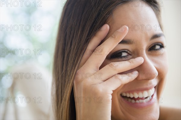 Close up of woman peering through fingers