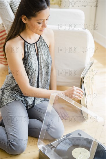 Woman listening to vinyl records in living room