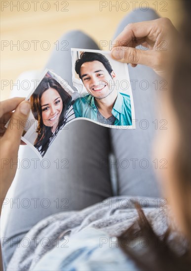 Woman tearing picture of herself with ex-boyfriend