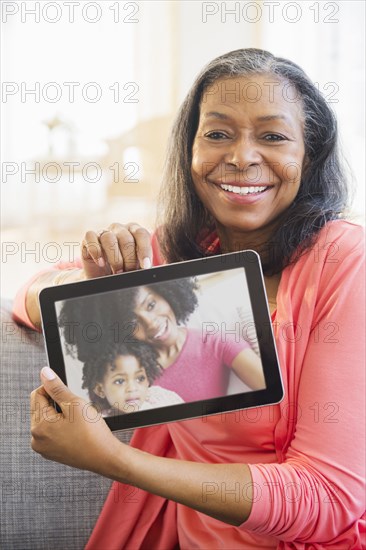 Mixed race woman using tablet computer on sofa