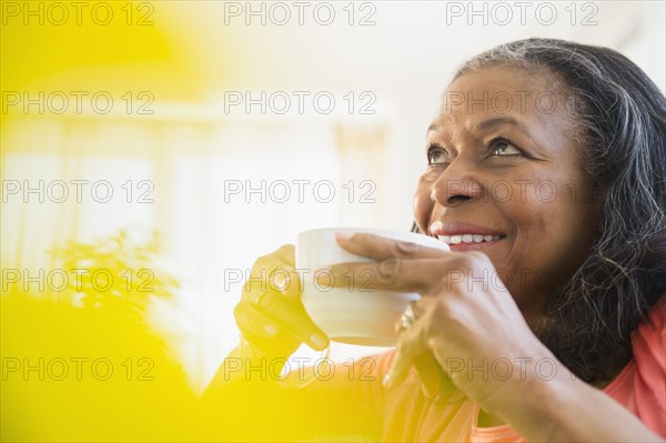 Mixed race woman drinking cup of coffee